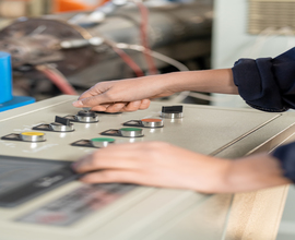paper 3 Hand of young female worker in overalls standing in front of control panel and turning knobs while preparing industrial machine for work
