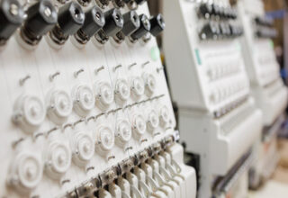 Industrial weaving loom at a weaving factory, embroidery machine, applying embroidery to fabric
