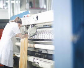 Woman working at machinery in laundry